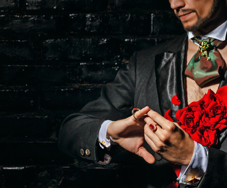 The young man is wizard corrects scarf and jewelry before performanceの写真素材