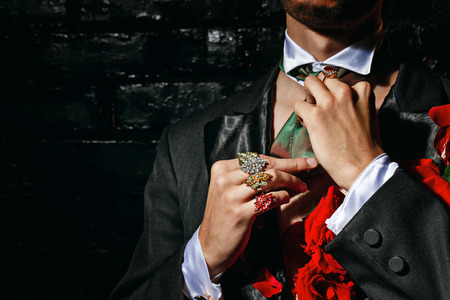 The young man is wizard corrects scarf and jewelry before performanceの写真素材