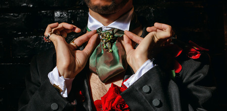The young man is wizard corrects scarf and jewelry before performanceの写真素材