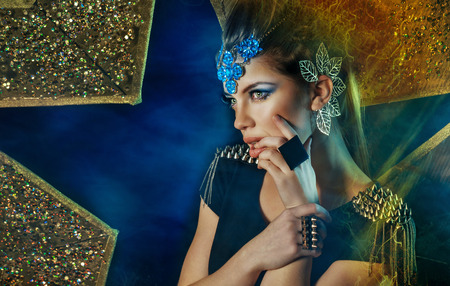 Attractive young girl posing with different accessories on a background of stars, shot using techniques mixed lightの写真素材