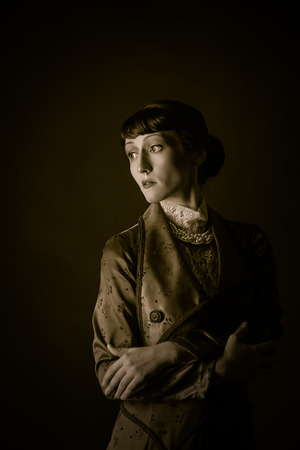 Attractive girl with a hairdress in retro dress posingの写真素材