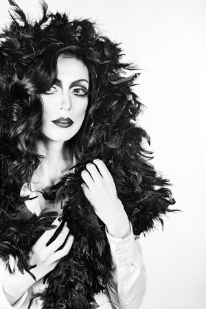 Portrait of girl with makeup and feather boa shot in high keyの写真素材