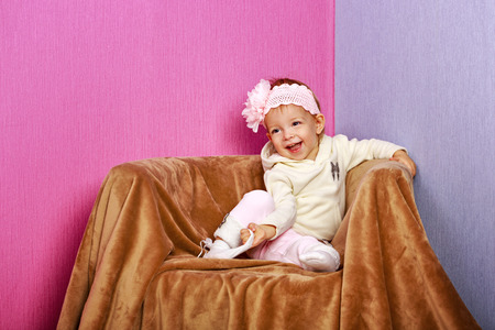 Little girl sitting in chair with a happy look on her face shot in home interiorの写真素材