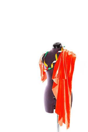 Mannequin with a piece of red cloth and a measuring tape. The concept of fashion and fashion design.の写真素材