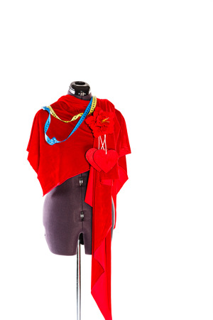 Mannequin with a piece of red cloth and a measuring tape, a flower and a heart from a fabric. The concept of fashion and fashion design.の写真素材