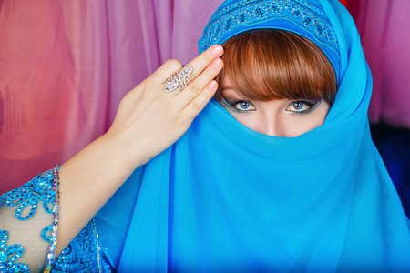 Young oriental beauty hides her face veil. The concept of the Arab harem.の写真素材