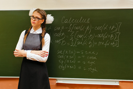 Excellent pupil stands at the blackboard with formulas for geometry. Lesson calculus. The concept of...