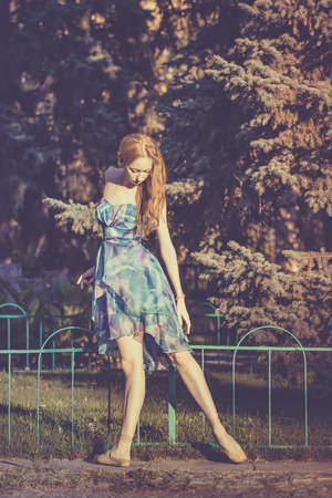 Young slim graceful ballerina dancing in the park. The concept of modern art.の写真素材