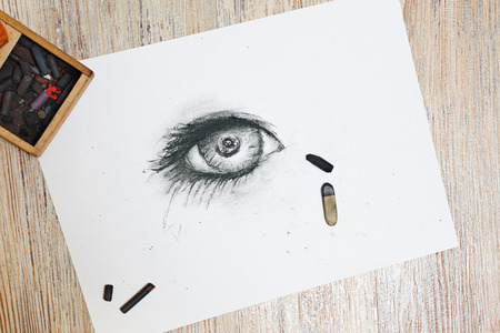 The human eye is drawn in charcoal on paper. The concept of creativity.の写真素材