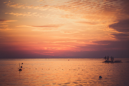 Sea fishing at sunset. Landscape of the sea and sunsets. Unrecognizable people silhouettes. The concept of rest.の写真素材