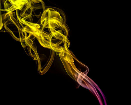 Abstract art. Color yellow-purple smoke from the aromatic sticks on a black background. Background for Halloween. Texture fog. Design element. The concept of aromatherapy.の写真素材