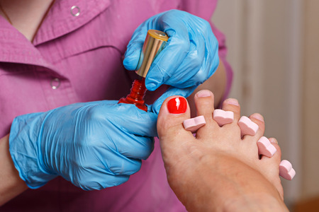 Master chiropody applying gel nail polish. Spa. Concept body care.の写真素材