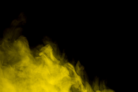 Abstract art. Yellow smoke hookah on a black background. Inhalation. The steam generator. The concept of poison gas.の写真素材