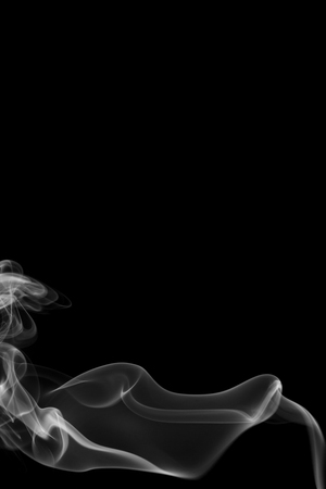 Grey smoke from the incense on a black background.の写真素材