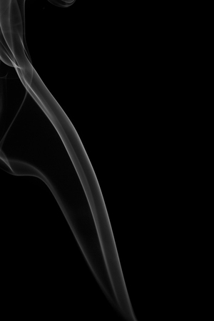 Grey smoke from the incense on a black background.の写真素材