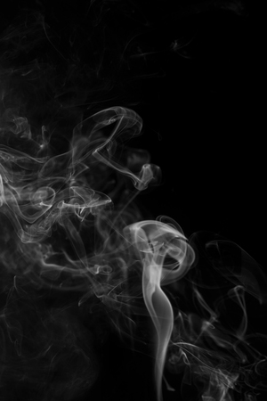 Grey smoke from the incense on a black background.の写真素材