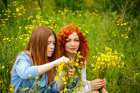 Girlfriends collect bouquets of wildflowers