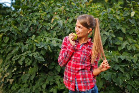 Young slim woman holding a green apple. Tasty and healthy snack. Raw food diet. Vegetarianism.の写真素材