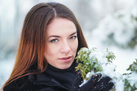 Sweetheart attractive girl in a fur coat and gloves in the winter park. Winter fun. Walks in the open air.の写真素材