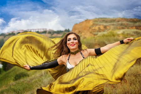 Oriental Beauty dance with wings. Nice girl in national dress dancing in the open air. Nomads. Grace.の写真素材