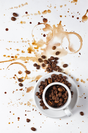 Coffee beans in an espresso cup. Prints of cups of coffee on a white sheet of paper. Coffee splashes. Favourite drink.の写真素材
