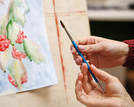 Girl paints still life in watercolor art school. The teacher helps to correct the defects in the picture. Hands close-up. Courses of drawing for adults.の写真素材