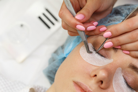 Beauty salon. The procedure of fastening the extended eyelashes. Shooting close-up. Aesthetic facial...