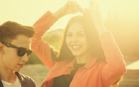 Loving teenagers in a city park at sunset. The guy in the sunglasses.の写真素材