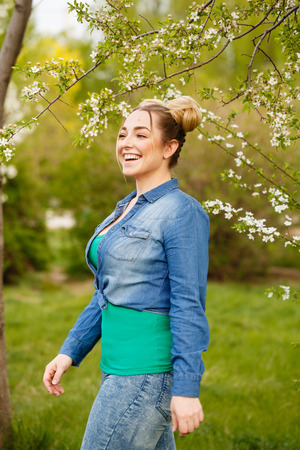 Young attractive girl is walking in the spring park and smilingの写真素材