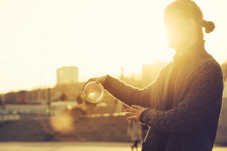 Contact juggling. Man balancing a glass bowl on a hand. Mastery of representation. Portrait at sunset. Trend viewの写真素材