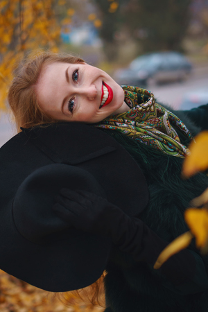 Red-haired girl in the autumn park.の写真素材