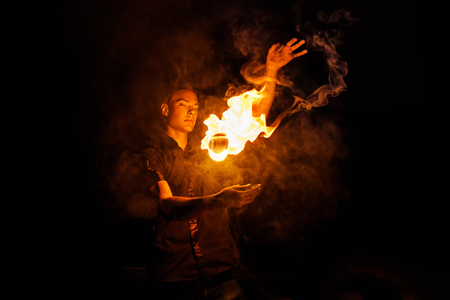 Fire show. Fakir juggles with fire Poi. Night performance. Illusion of a suspended objectの写真素材