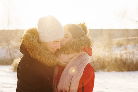Adolescents in love on date in winter. Girl kisses her boyfriend. Joy of being together. First love. Concept for Valentine's Day.の写真素材