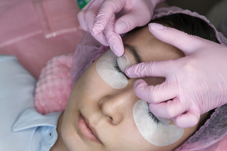 Eyelash extension procedure. Female eyes with long eyelashes. Cosmetic procedure in spa salon. Workshop cosmetologistの写真素材