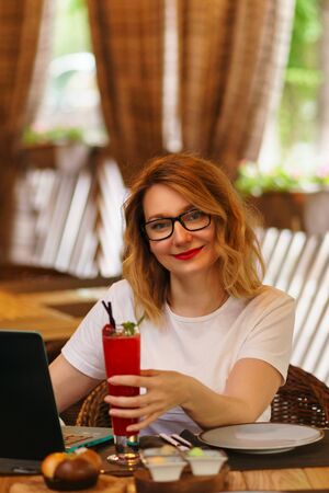Business lady received compliment from restaurant. She enjoys refreshing non-alcoholic cocktail on restaurantâs summer terrace. Work will wait. Business lunchの写真素材