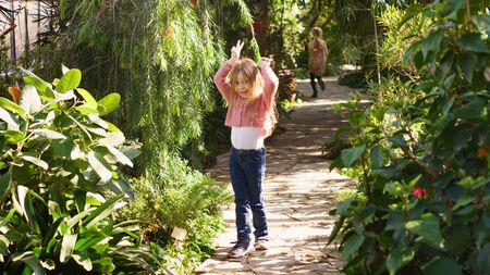 Springtime. Weather forecast. Little schoolgirl in sunny spring. Portrait of prank girl in botanical garden.  Excursion in greenhouse. Happy childhood.の写真素材