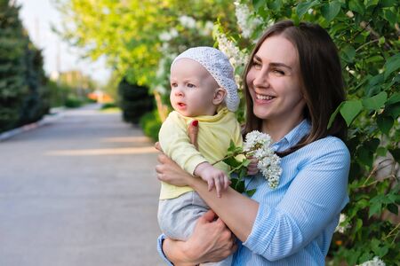 Young loving mother on maternity leave. Mother and cute toddler daughter enjoy a walk. Happiness to be a parent. Relaxing outdoors.の写真素材