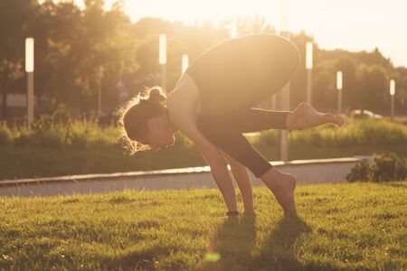 Yoga is the best holistic workout. Mental and physical health. Yoga instructor with do sport. Girl performs yoga in a park on International Yoga Dayの写真素材