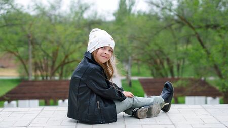 Lovely moments of little child enjoying walk in the city. Schoolgirl dressedtrendy denim urban casual outfit. Expressing true positive emotions of fashionable happy child at entertainmentの写真素材