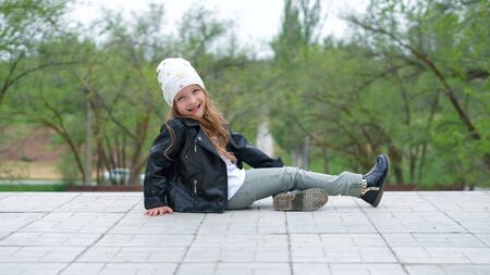 Lovely moments of little child enjoying walk in the city. Schoolgirl dressedtrendy denim urban casual outfit. Expressing true positive emotions of fashionable happy child at entertainmentの写真素材