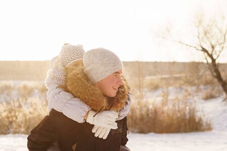 Joyful brother and sister spend time together on a walk in the winter park on a sunny day. Having fun playing in snow outdoors. Winter best time for cheeryの写真素材