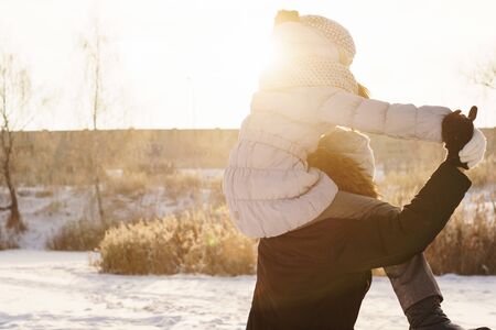 Joyful brother and sister spend time together on a walk in the winter park on a sunny day. Having fun playing in snow outdoors. Winter best time for cheeryの写真素材