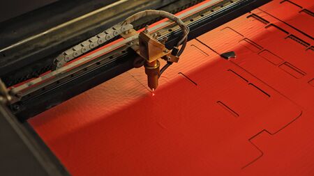 Laser cutting beam high precision on a paperboard. Modern machine industrial technology of paperboard cutting. Industrial laser engraving. CNC laser. Masterclass, workshop sessionの写真素材
