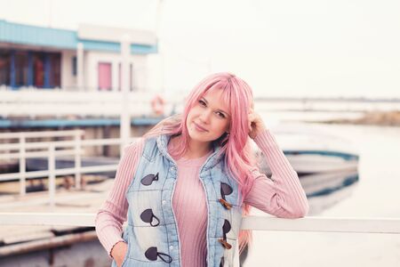 Closeup portrait of a charming dreamer girl with long pink hair. Modern fashion trends. Last warm days. Enjoy the good weather for a walk. Lifestyle. People, street style and holidays concept.の写真素材