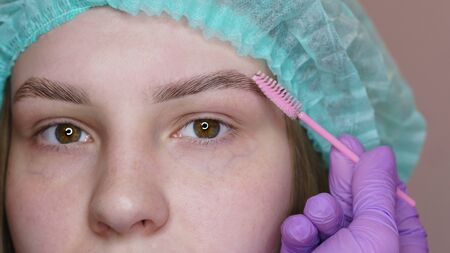 Long-lasting eyebrow styling. Eyebrow biolamination. Master gives right shape to eyebrows for hair growth. Cosmetic procedure in spa salon. Beautician at work..の写真素材