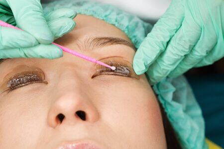Eyelash care treatment procedures. Staining, curling, laminating for lashes. Beauty model with...