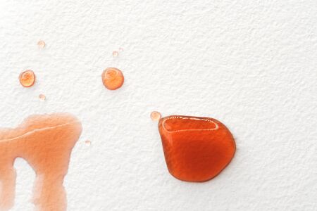 Abstract liquid drops splash fresh pomegranate juice on a white texture paper background for watercolor. Artistic decoration or backdrop. Banner for text, grunge element. Glare in reflectionの写真素材