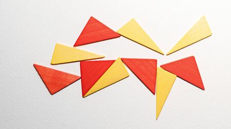 Different colorful triangles wooden on white background. Geometric shapes red, yellow colors, top...