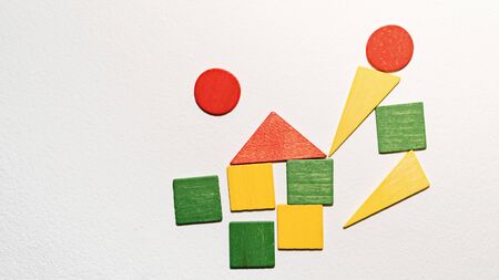 Different colorful shapes wooden on white background. Geometric shapes red, green, yellow colors, top view. Concept of geometry. Copy space. Children educational logical task. Flat lay.の写真素材