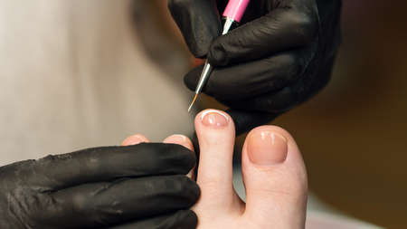 Process pedicure close up in a fashionable spa salon, unrecognizable people. French pedicure, white...